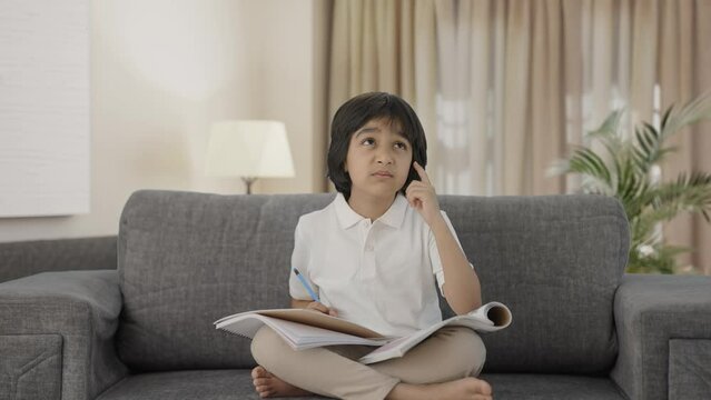 Confused Indian boy reading and studying