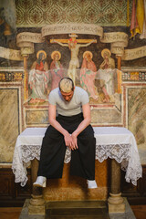 Obraz premium Contemplative man seated before religious frescoes