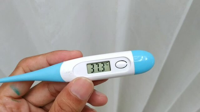 The body thermometer in his hand showed a temperature of 37.3 degrees Celsius