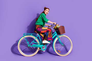 Full length photo of terrified girl wear shirt print trousers driving away bicycle to empty space...