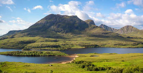 Views of Sgorr Tuath and Loch Lurgainn with Beinn an Eoin, Sgurr an Fhidhleir and Ben More Coigach behind in the Scottish Highlands on a sunny summers day in the UK
