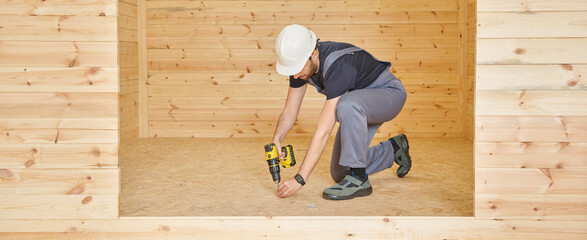 Construction man, builder man construct new wooden home, tiny house style. Spirit level, screw,...