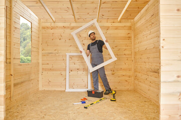 Construction man, builder man construct new wooden home, tiny house style. Spirit level, screw,...