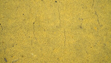 Close-up road texture painted yellow as background. yellow dividing line road close up