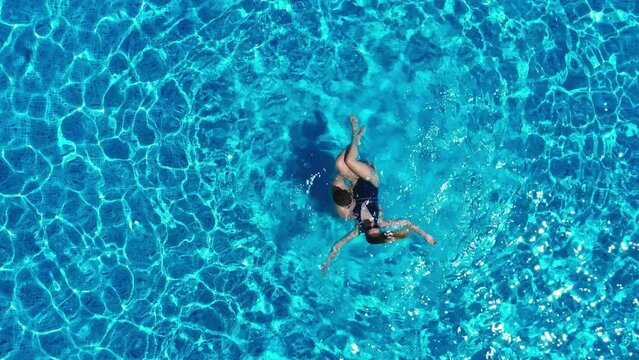 View from above. The couple have fun in the pool. A young attractive couple is relaxing in the pool. Enjoying each other's company.