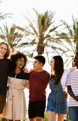Vertical photo of young group of happy diverse friends laughing while enjoying summer vacation...