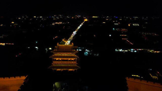 Drone flying over South Gate of Pingyao, Chinese old town at night