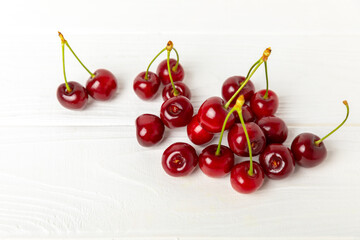 Cherries. Fresh ripe cherries with leaves on a textured wooden background. Fresh sweet organic cherry pile. Berries and fruits. Vegan. Healthy eating. Place for text. Copy space