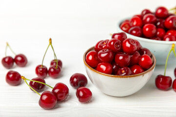 Cherries. Fresh ripe cherries with leaves on a textured wooden background. Fresh sweet organic cherry pile. Berries and fruits. Vegan. Healthy eating. Place for text. Copy space