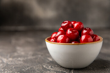 Cherries. Fresh ripe cherries with leaves on a textured wooden background. Fresh sweet organic cherry pile. Berries and fruits. Vegan. Healthy eating. Place for text. Copy space