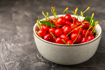 Cherries. Fresh ripe cherries with leaves on a textured wooden background. Fresh sweet organic...