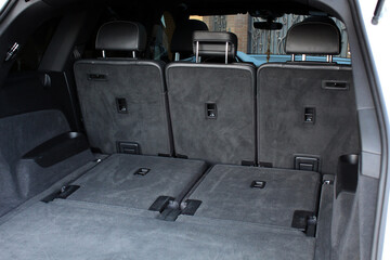 Rear view of the car open trunk. Car big trunk open. Lux SUV car have an open trunk. Modern car boot is open and ready for luggage loading. Left view.