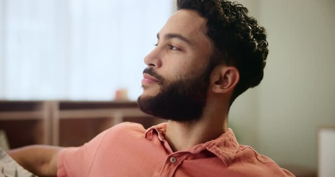 Man, thinking and breathing with relax on sofa for holiday, weekend or break in living room at home. Young or happy male person with smile in wonder or thought on couch for morning, start or day