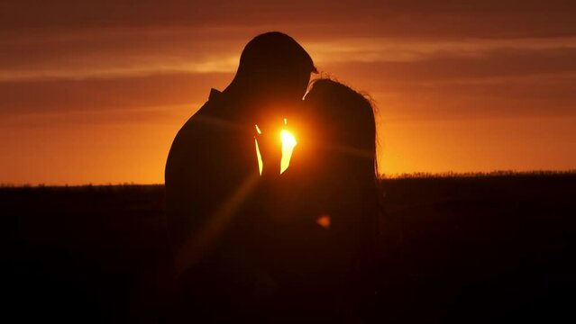 Silhouette of a couple in love in glamor romance at sunset. Love story concept. - Powered by Adobe