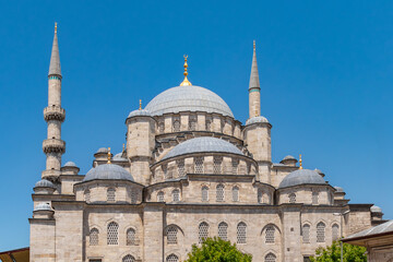 Fototapeta premium View of the dome and minarets with a blue isolated sky from outside the New Mosque in Eminönü, Istanbul.