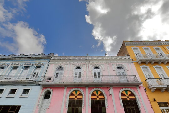 West-facing colonial buildings painted pale blue-pink-saffron yellow on the east side of the Parque Serafin Sanchez Park. Sancti Spiritus-Cuba-326