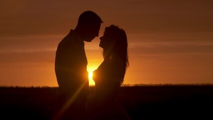 Silhouette of a couple in love in glamor romance at sunset. Love story concept. - Powered by Adobe