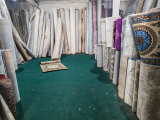 Many rolled carpets in Asian carpet store and carpet warehouse.