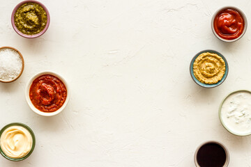 Set of sauces in bowls - pesto salsa mustard and others. Food background