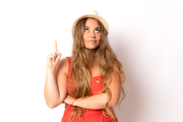 Portrait of a young blonde girl wearing straw hat pointing up