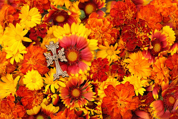 orange-red colorful flowers and wooden christian cross on table. Symbol of the death and resurrection of Jesus Christ, Faith of God, Hope, Love. Religious church holiday. top view. close up