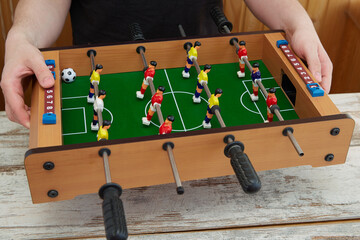 Hands holding a foosball game, Tabletop sports game in soccer, Close-up