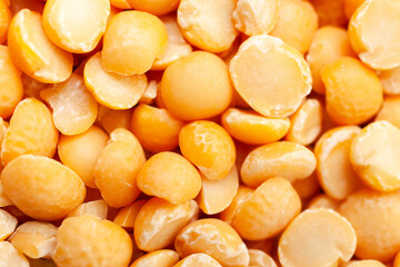 Uncooked, split, yellow peas background. Dry peas grains. Top view. Close-up