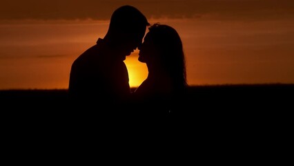 Silhouette of a couple in love in glamor romance at sunset. Love story concept.