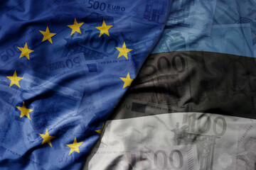 big waving realistic national colorful flag of european union and national flag of estonia on a euro money banknotes background.