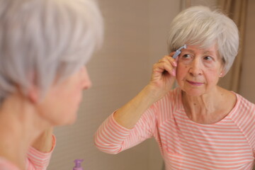 Lady shaving her extra eyebrow hairs 