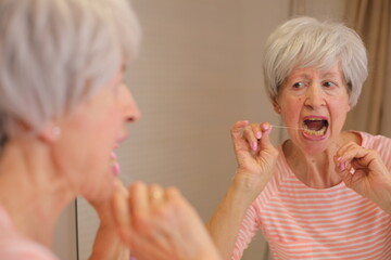 Mature woman trying to floss 