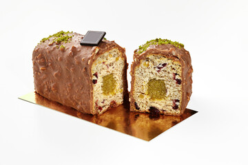 Sliced chocolate glazed loaf cake with fruit jelly, dried berries and nuts