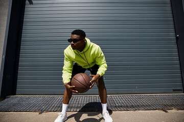 Fototapeta premium Handsome man in yellow hoodie with basketball.