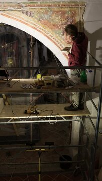 Hard Work of Patience and Expertise from Woman Restorer in Renovation process of an ancient fresco in a church
