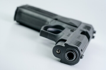 A detailed view of a gun, with its various components visible, set against a plain white backdrop