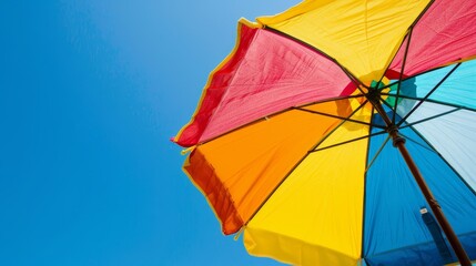 Colorful beach umbrella against a bright blue sky, highlighting its cheerful shade. Perfect for summer and vacation themes