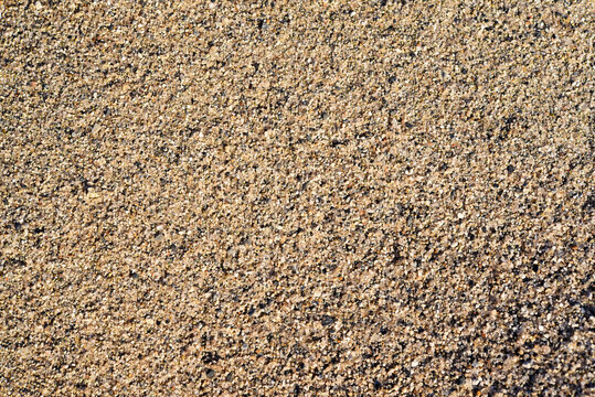 The river sand is coarse-grained. Small pebbles of river sand. Macrophotography of sand.