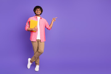 Full size photo of nice young man hold book point finger empty space wear shirt isolated on violet color background