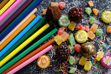 Sweets and pencils on sugarly background