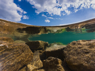 Action cameta underwater photography at the Rummu quarry, clear water, rocky bottom and cloudy sky.