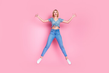 Full length photo of shiny attractive lady dressed blue top jumping high empty space isolated pink color background