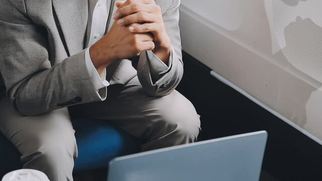 successful asian businessman in suit and glasses sits in private jet and uses smartphone, korean entrepreneur flies in an airplane and types on the phone online
