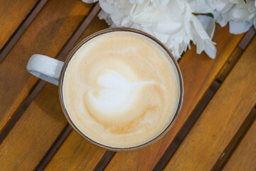 A single cup of coffee placed on top of a wooden table