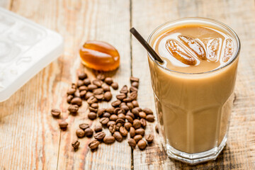 Ice coffee with milk and beans for lunch on wooden background