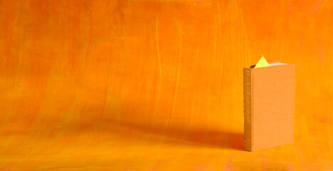 orange colored book in front of orange background,business,education is power,reading,knowledge...