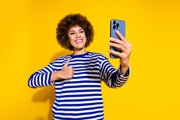 Photo of cute woman with perming coiffure wear striped shirt show thumb up make selfie on...