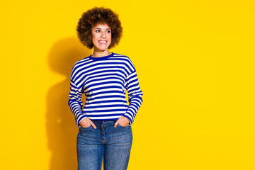 Portrait of pretty young woman look empty space ad wear striped shirt isolated on yellow color background