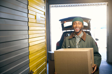 Man is holding a box in his hands in the storage service