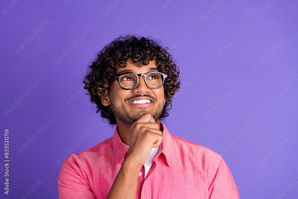 Wall mural Photo of nice young man hand chin look empty space wear pink shirt isolated on violet color background