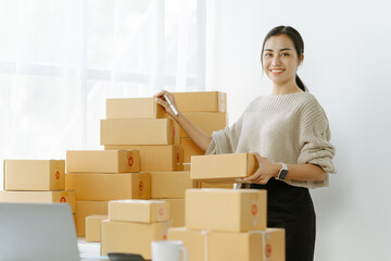 businesswoman start small business and successful SME entrepreneurs asian woman hoding boxs works from home delivering parcels online. SME delivery